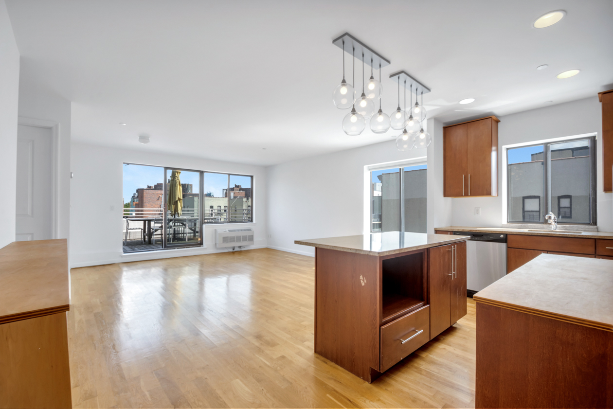 416 East 117th Street, Unit PH6 Manhattan, NY 10035 - Photo 7 of 20 a living room with stainless steel appliances kitchen island granite countertop a sink dishwasher a stove and a dining table with wooden floor