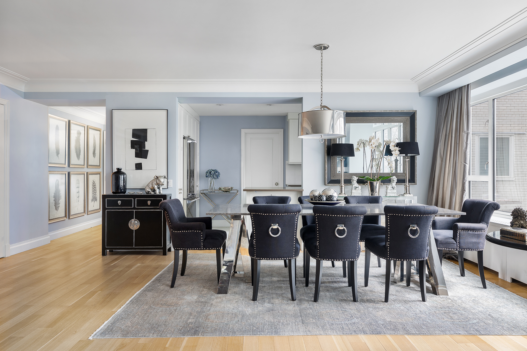200 East 66th Street, Unit E207 Manhattan, NY 10065 - Photo 3 of 12 a kitchen with stainless steel appliances granite countertop a dining table chairs stove a refrigerator and a window