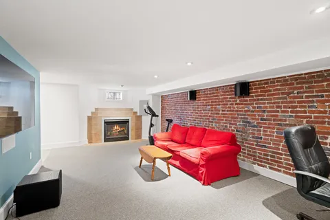 a living room with furniture wall paintings a fireplace and a flat screen tv