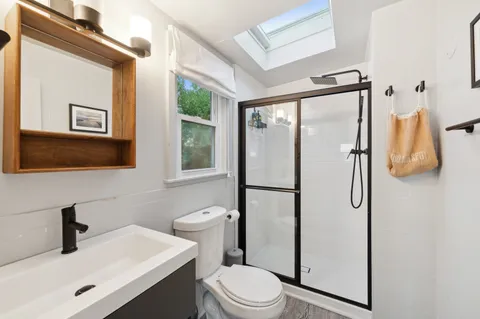 a bathroom with a toilet a sink and mirror