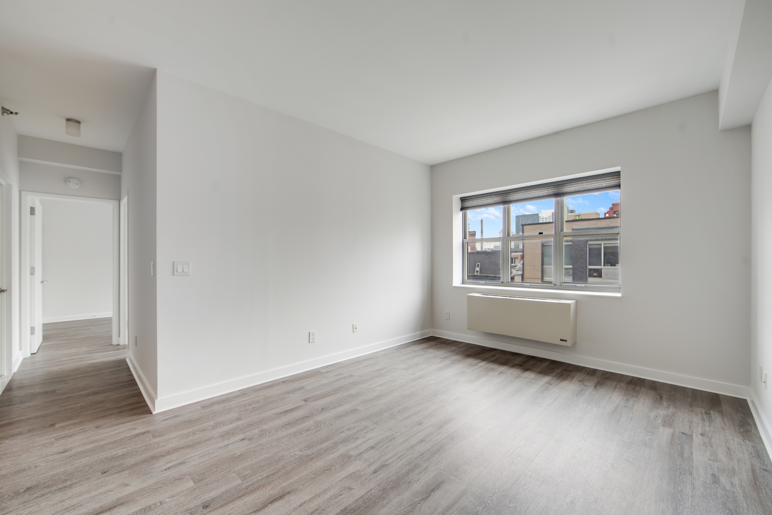 516 West 47th Street, Unit N7A Manhattan, NY 10036 - Photo 5 of 19 a view of an empty room with wooden floor and a window