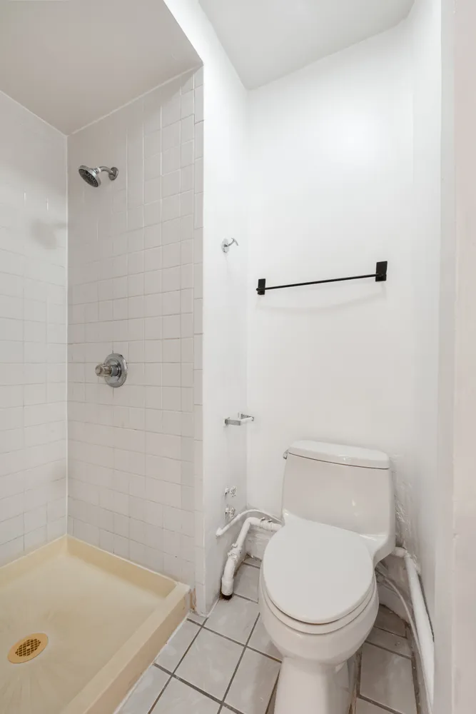 a bathroom with a toilet and a shower