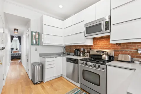 a kitchen with stainless steel appliances granite countertop a stove a sink and a microwave