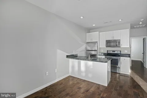 a kitchen with stainless steel appliances granite countertop a refrigerator and a stove top oven