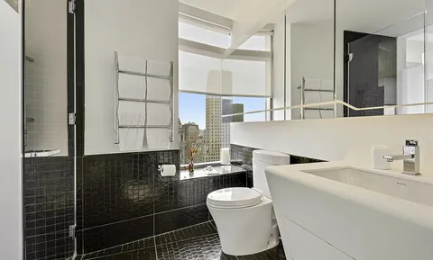 a bathroom with a sink a toilet and a mirror