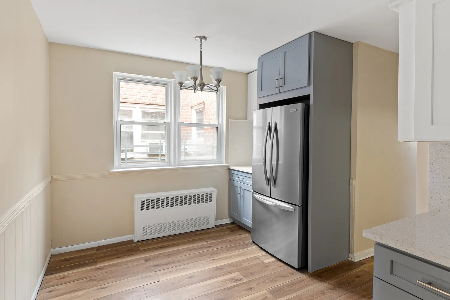 a view of an empty room with a window and wooden floor