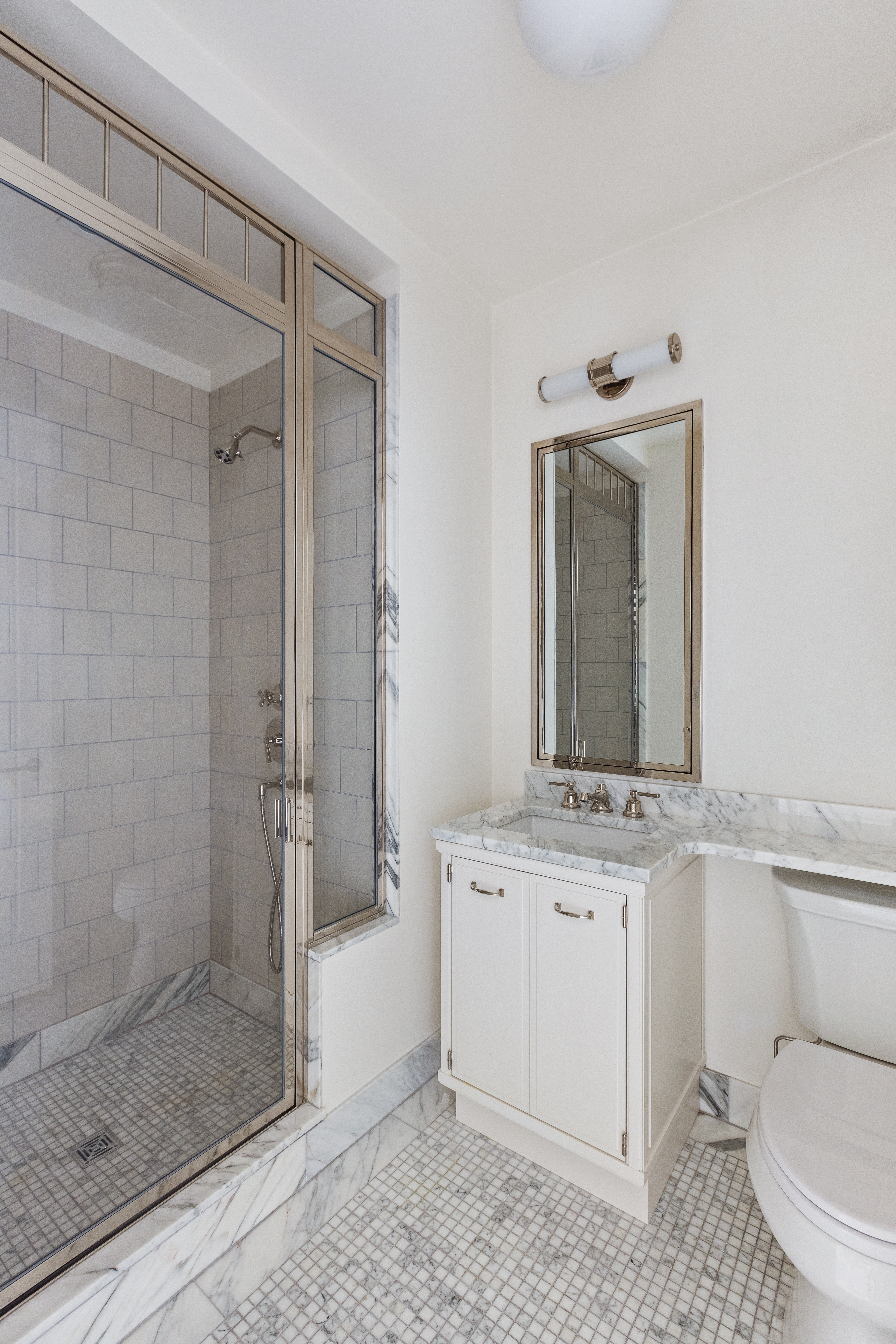 155 West 11th Street, Unit 14D Manhattan, NY 10011 - Photo 8 of 12 a bathroom with a granite countertop sink toilet a mirror and shower