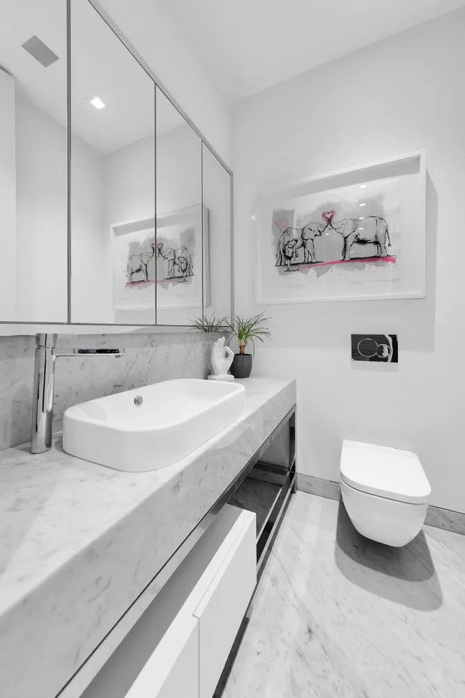 a bathroom with a sink a toilet and a mirror