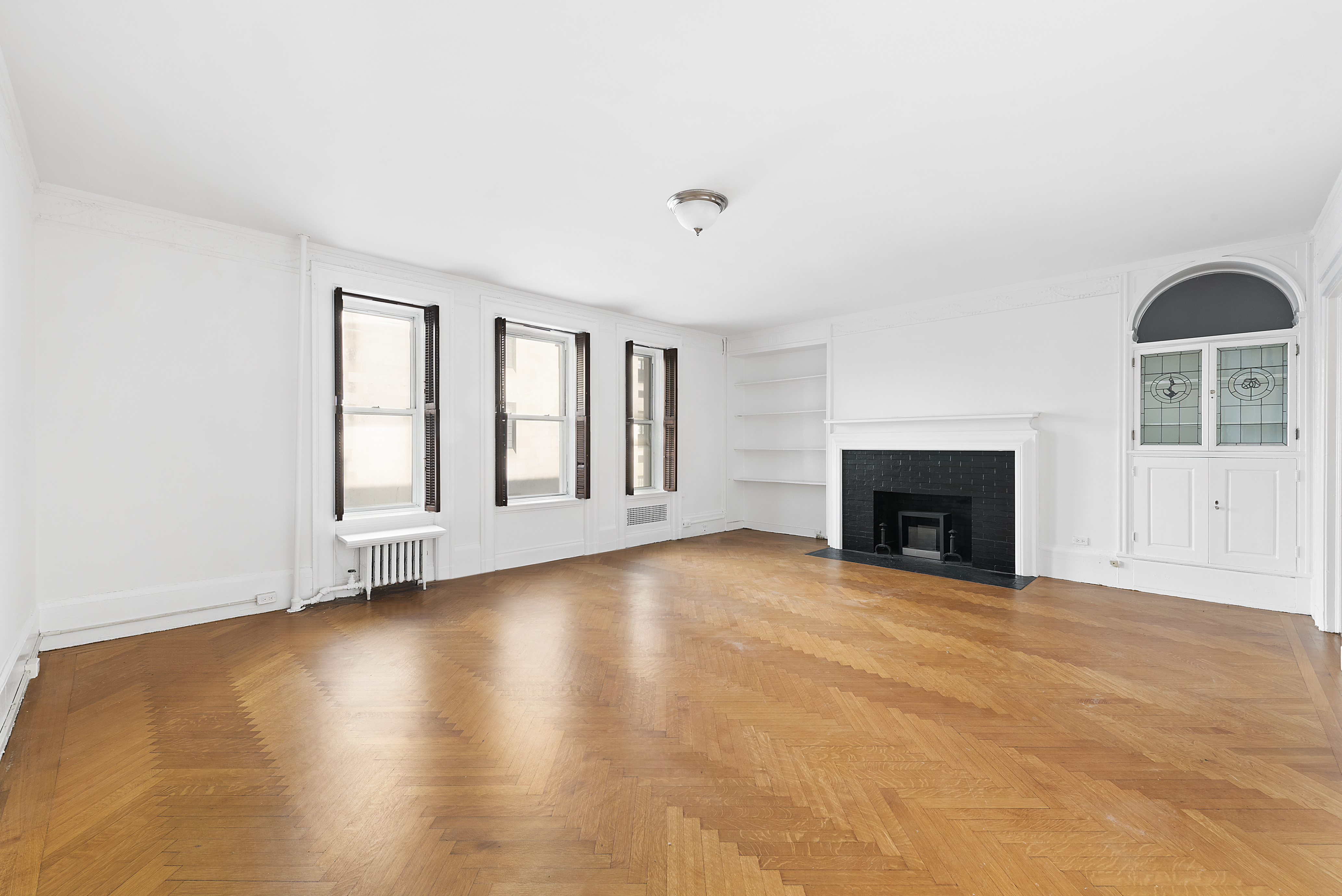 6 East 65th Street, Unit 4A Manhattan, NY 10065 - Photo 1 of 6 a view of an empty room with a fireplace and a window