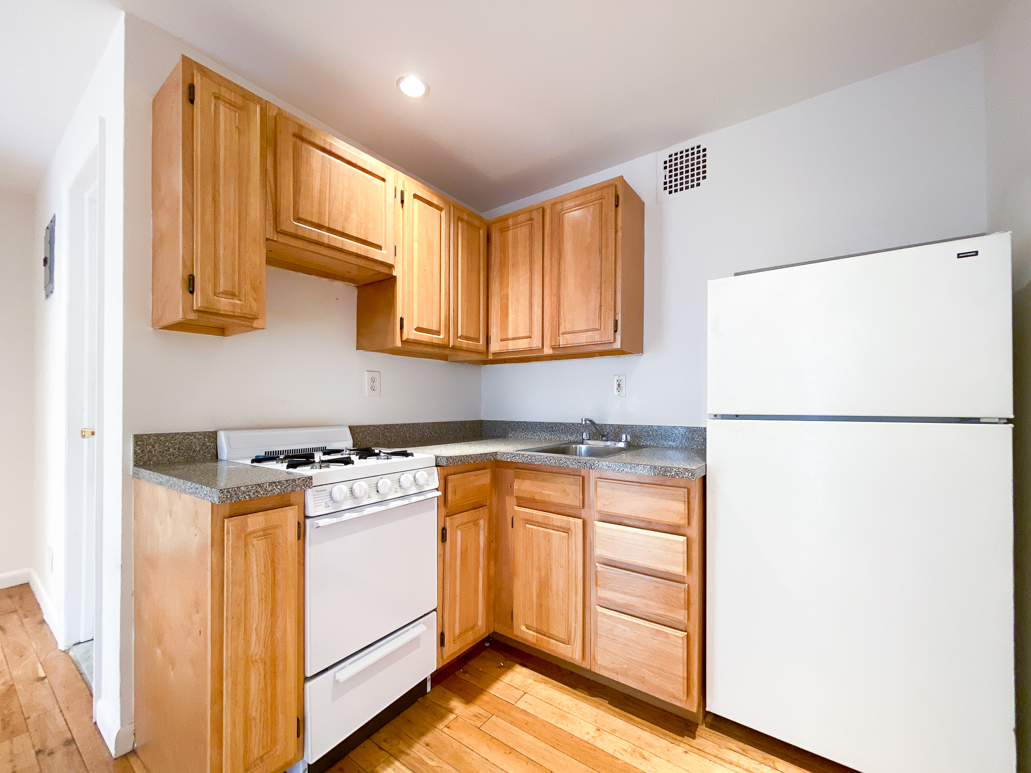 157 East 3rd Street, Unit 2B Manhattan, NY 10009 - Photo 5 of 18 a kitchen with a refrigerator a stove a microwave and cabinets