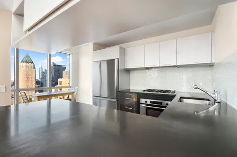 a kitchen with granite countertop a stove and a refrigerator