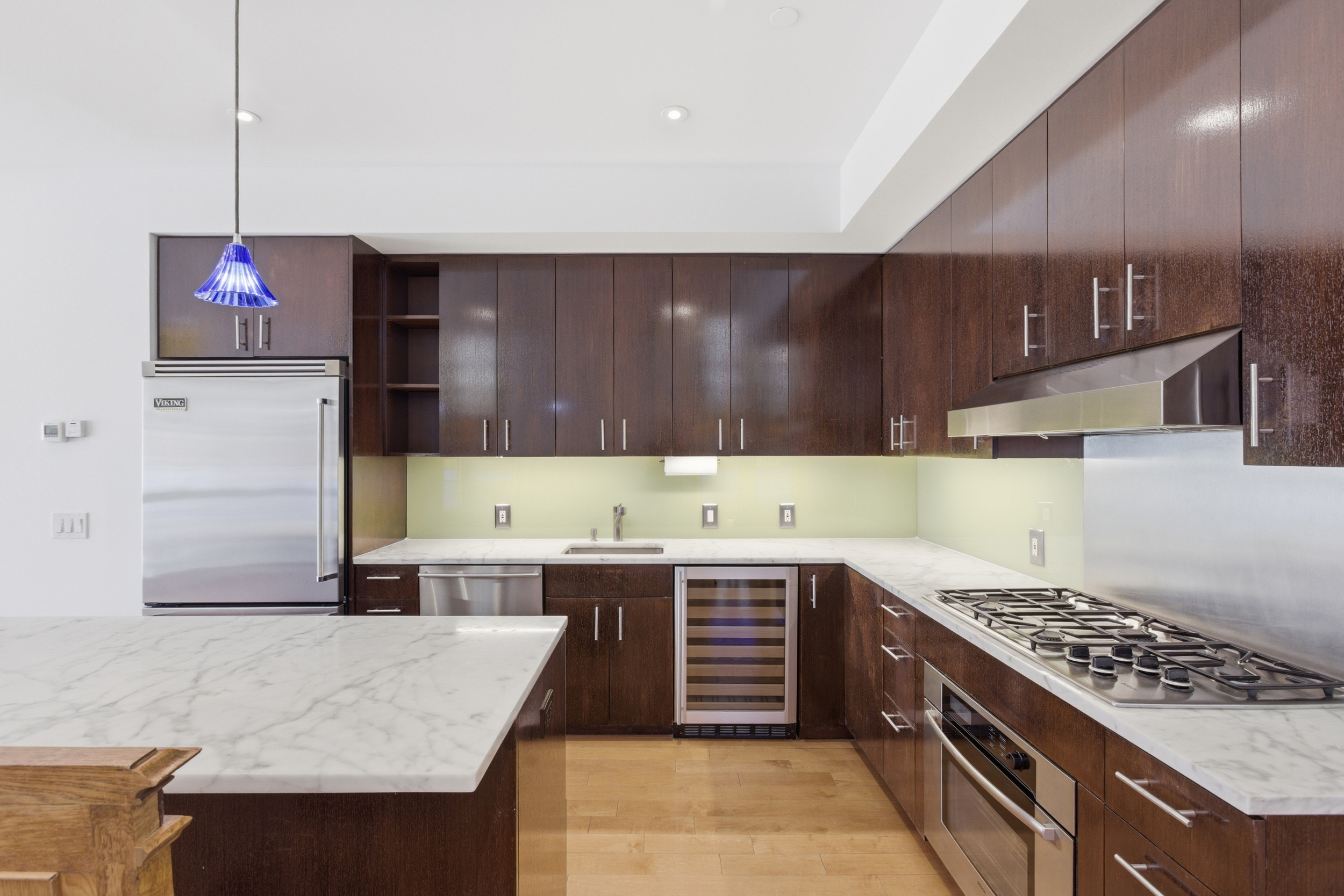 135 West 4th Street, Unit 3W Manhattan, NY 10012 - Photo 8 of 24 a kitchen with a sink a stove and a wooden cabinets