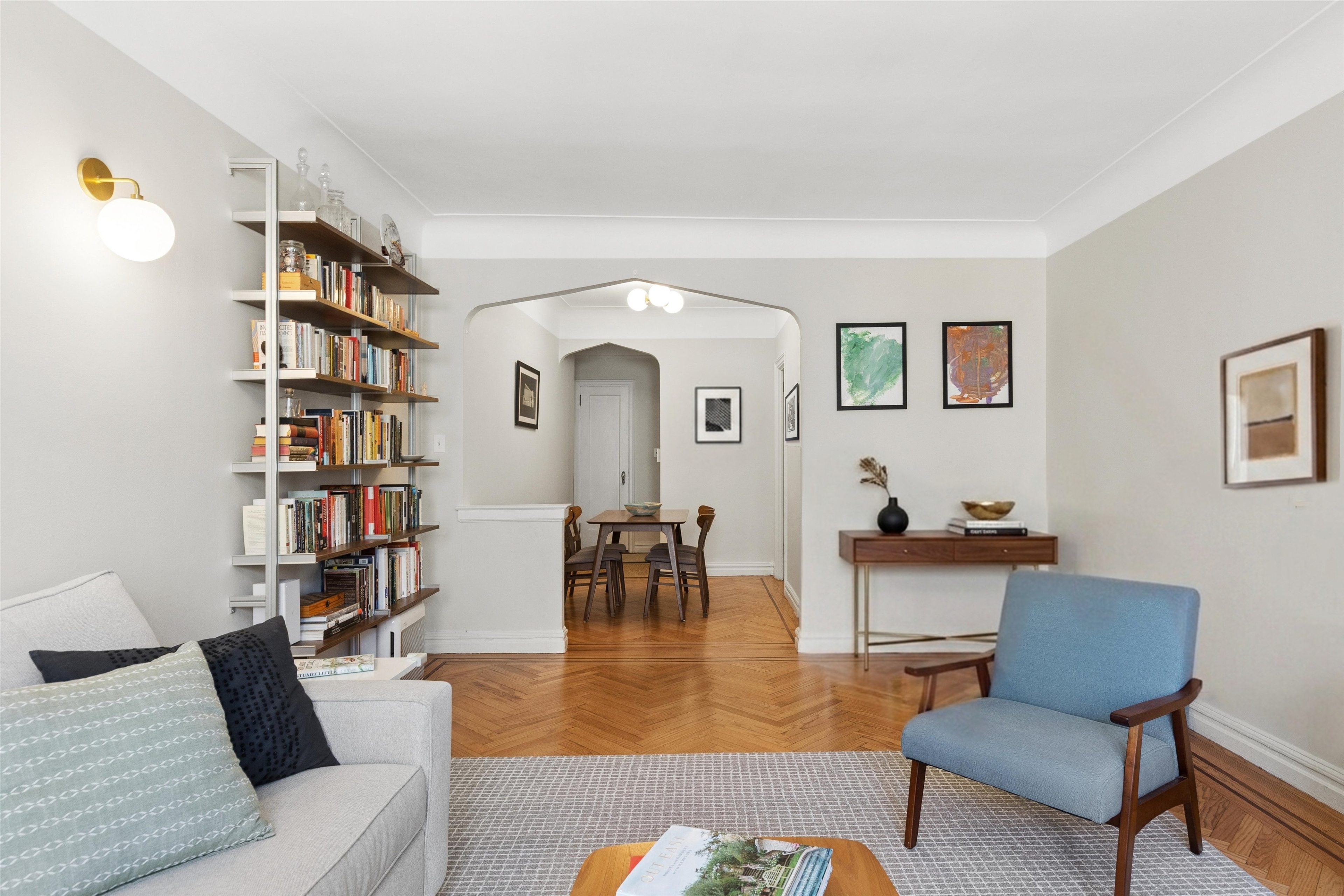 680 West 204th Street, Unit 5F Manhattan, NY 10034 - Photo 2 of 15 a living room with furniture and a book shelf