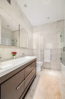 a bathroom with a double vanity sink toilet and a shower