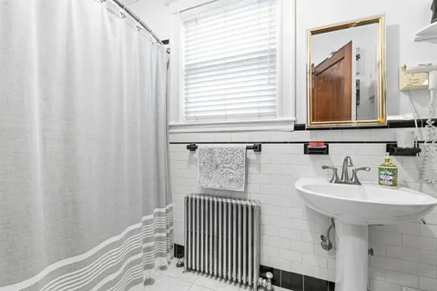 a kitchen with stainless steel appliances granite countertop a stove a sink dishwasher and white cabinets next to a window