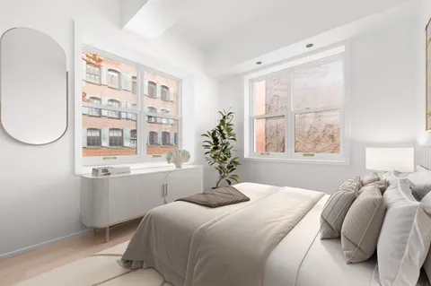 a bedroom with a large bed and windows