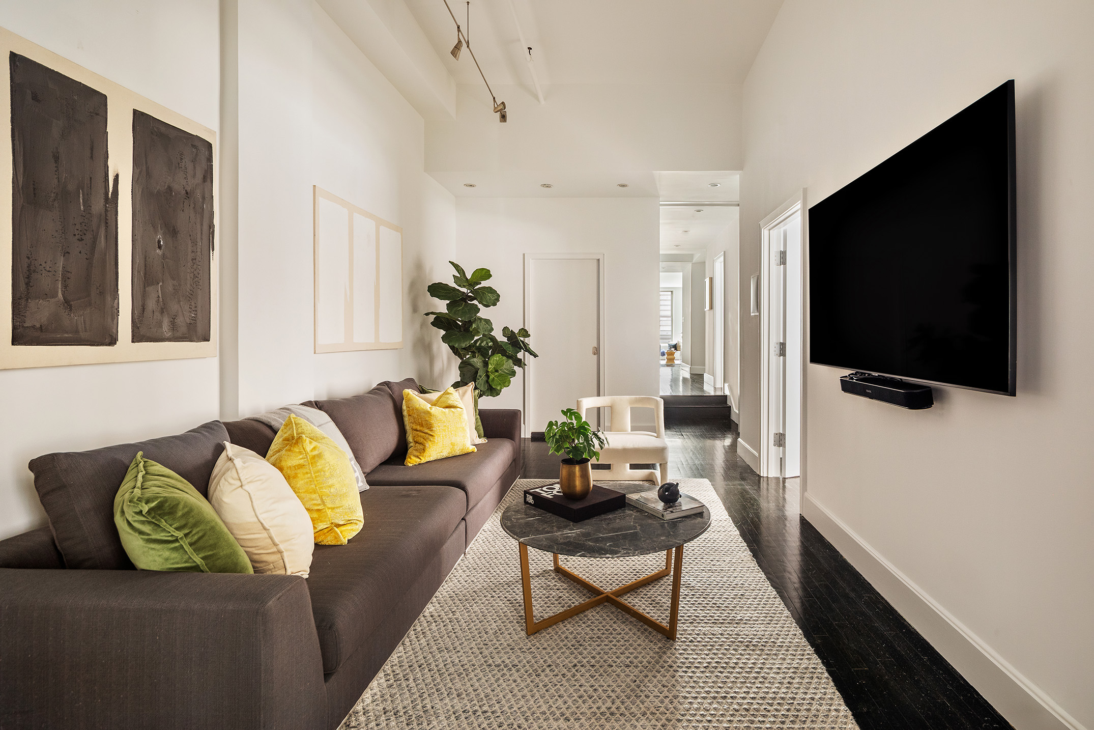 142 5th Avenue, Unit 2 Manhattan, NY 10011 - Photo 10 of 18 a living room with furniture and a flat screen tv