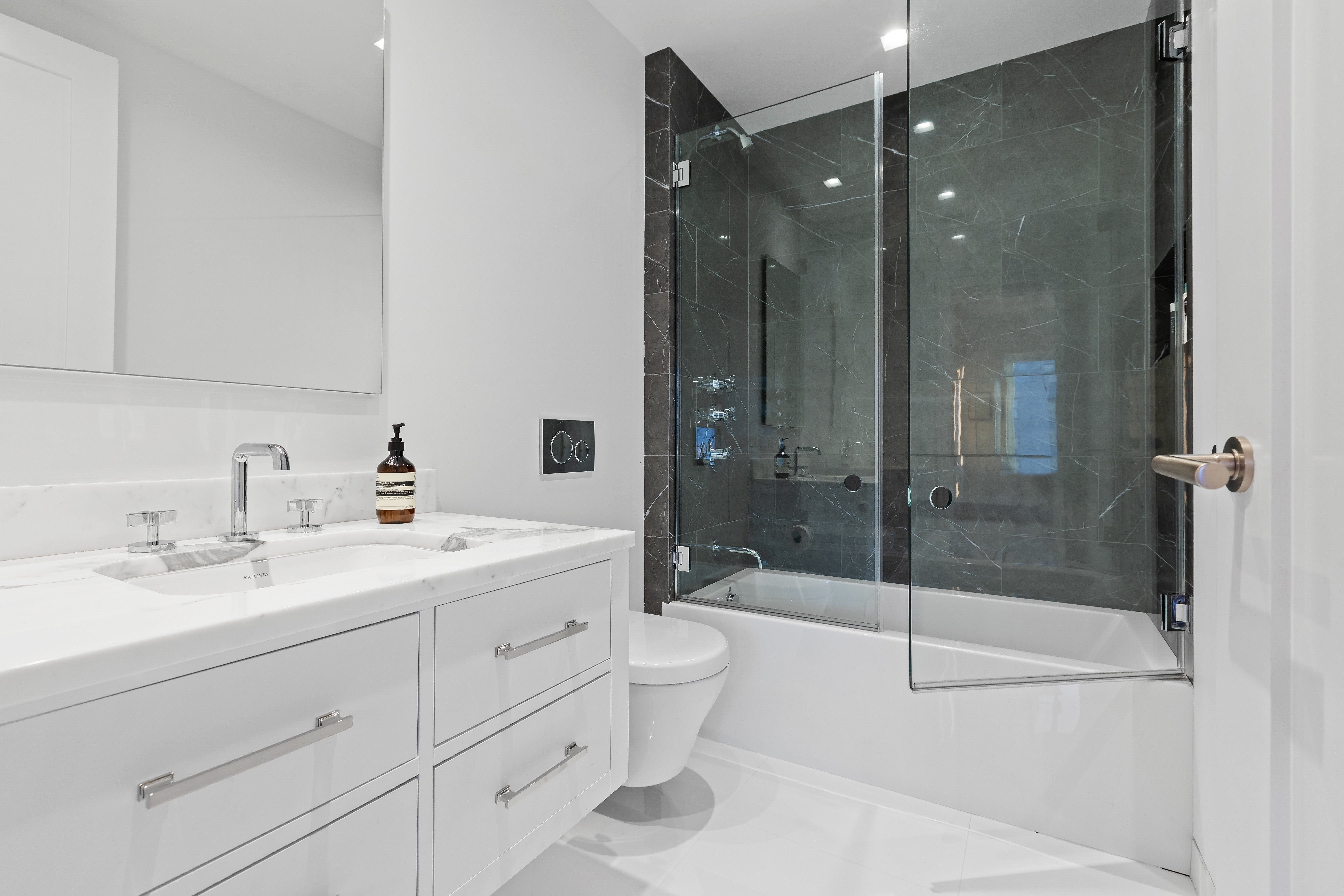 1 5th Avenue, Unit 16F Manhattan, NY 10003 - Photo 20 of 23 a bathroom with a shower sink vanity mirror and toilet