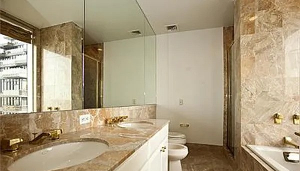 845 United Nations Plaza, Unit 56E Manhattan, NY 10017 - Photo 18 of 28 a bathroom with a granite countertop sink a toilet and shower