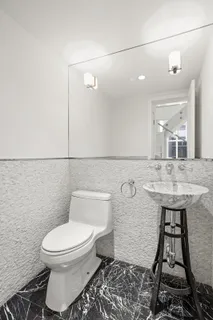 a bathroom with a toilet a sink and mirror