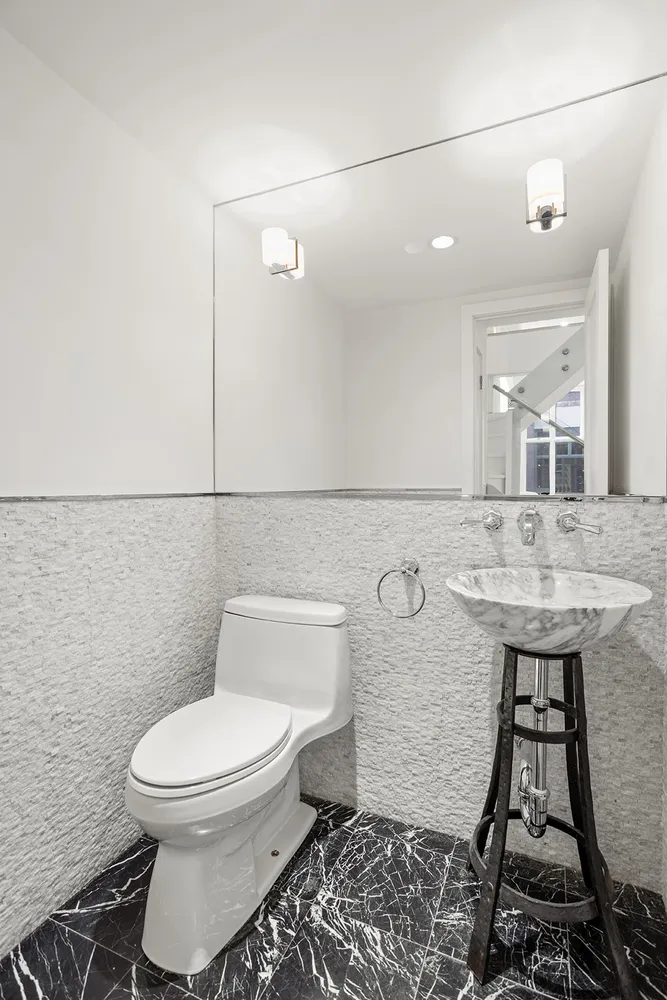 a bathroom with a toilet a sink and mirror