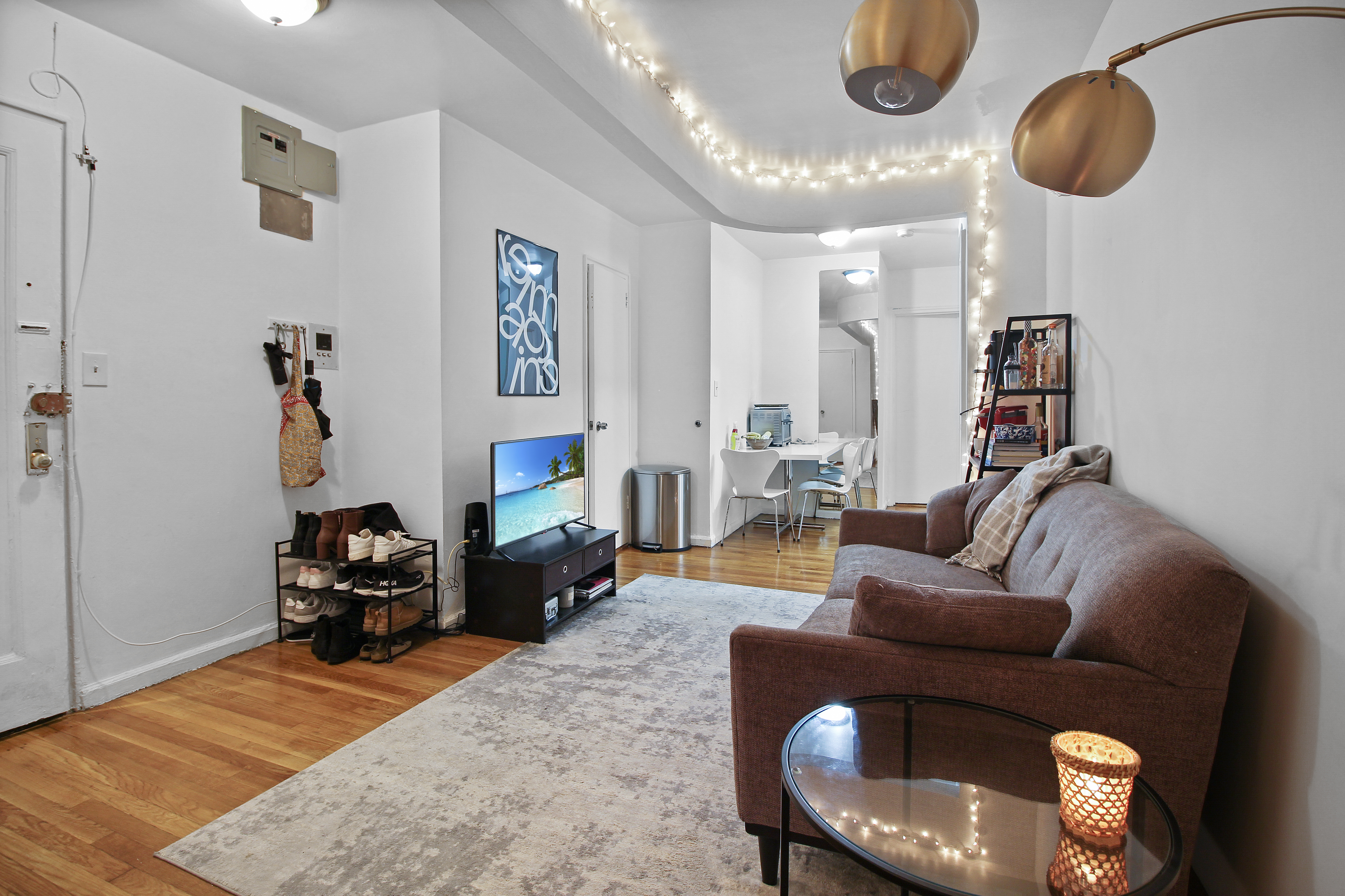 315 East 56th Street, Unit 5F Manhattan, NY 10022 - Photo 2 of 9 a living room with furniture and a chandelier