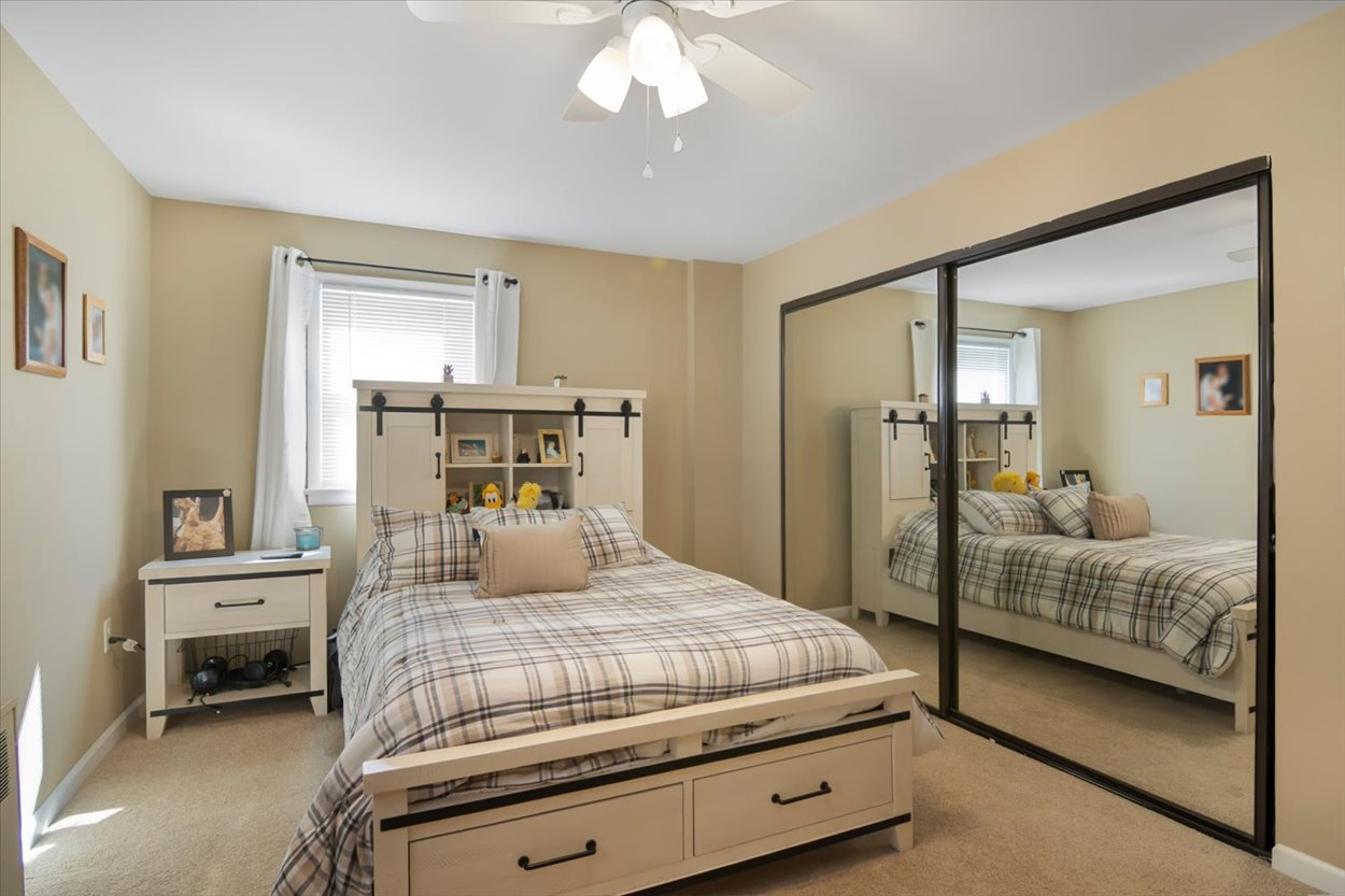 107 Kingston Road Parsippany, NJ 07054 - Photo 19 of 43 a bedroom with a large bed and a chandelier