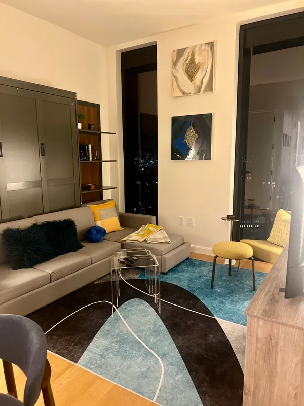 a living room with furniture pool table and painting on the wall