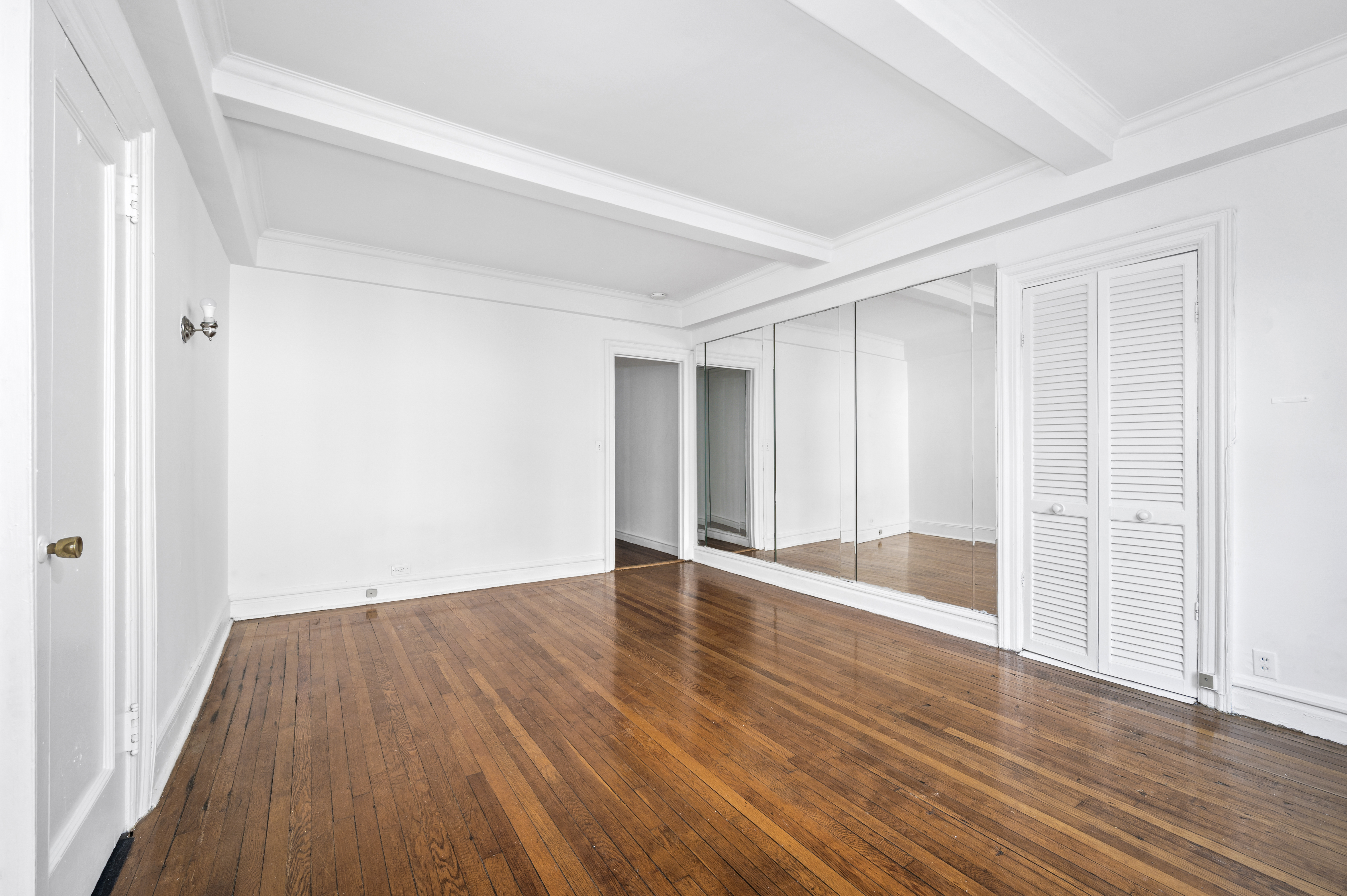17 West 64th Street, Unit 6E Manhattan, NY 10023 - Photo 2 of 6 a view of an empty room with wooden floor and a window