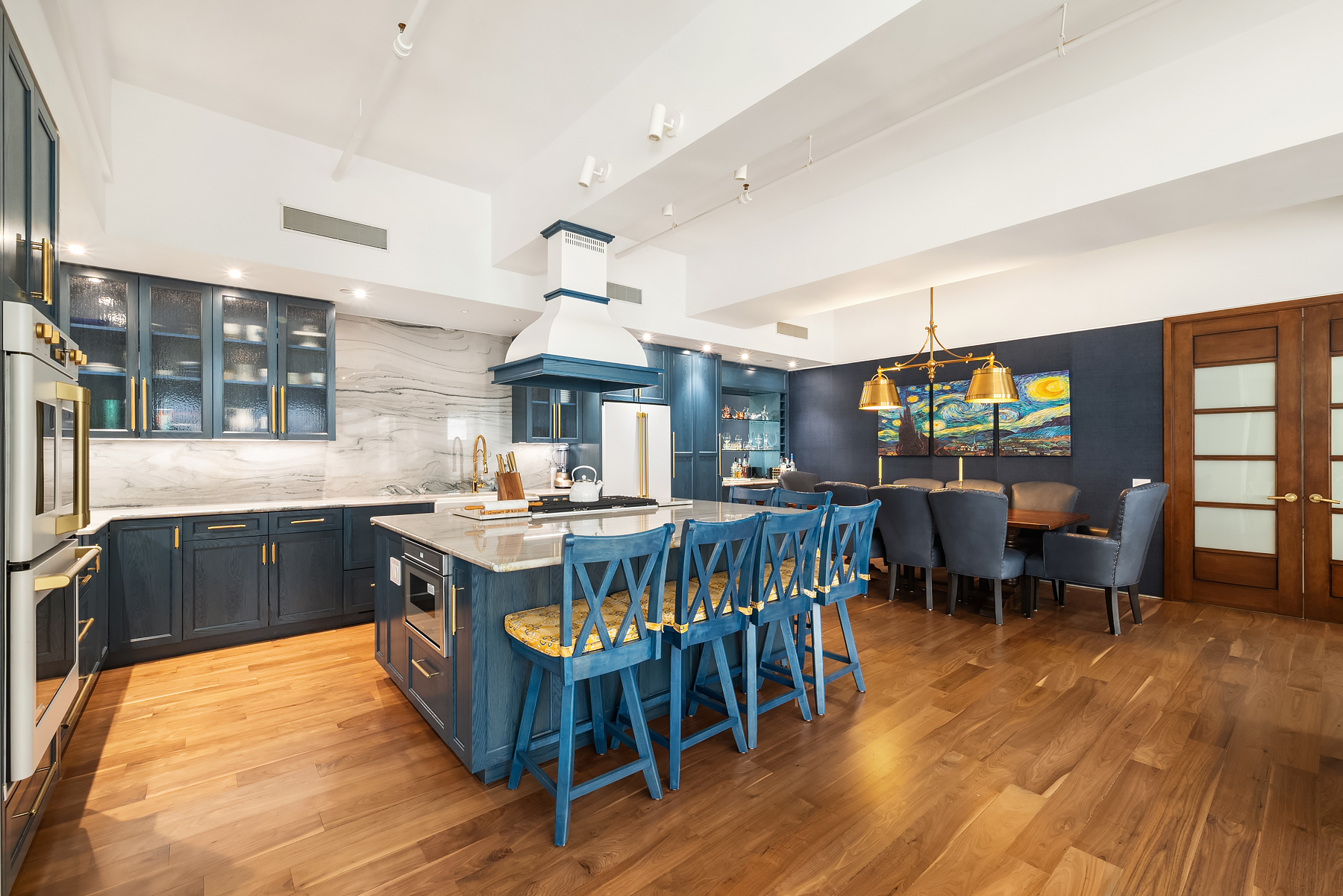 315 West 36th Street, Unit 11D Manhattan, NY 10018 - Photo 2 of 10 a kitchen with a table chairs wooden floors and a view of living room