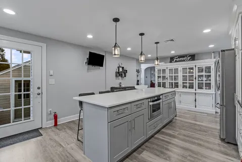 a kitchen with a stove and a wooden floor
