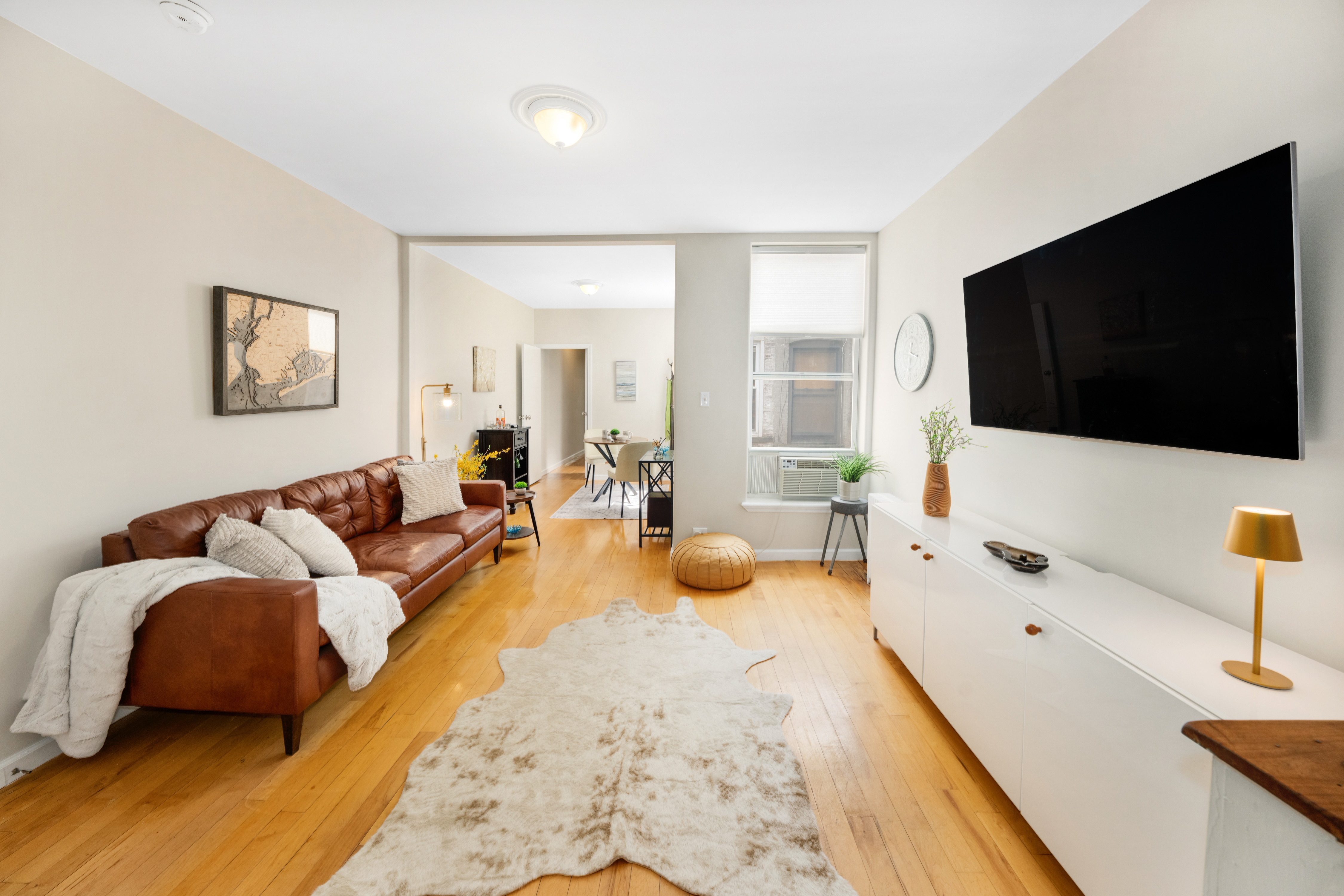 1286 Halsey Street, Unit 3B Brooklyn, NY 11237 - Photo 1 of 10 a living room with furniture and a flat screen tv