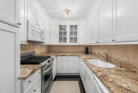 a kitchen with stainless steel appliances granite countertop a sink stove and cabinets