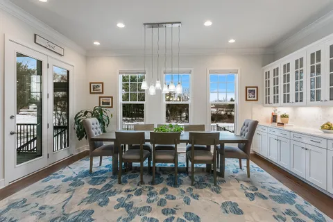 a dining room with wooden floor and a rug