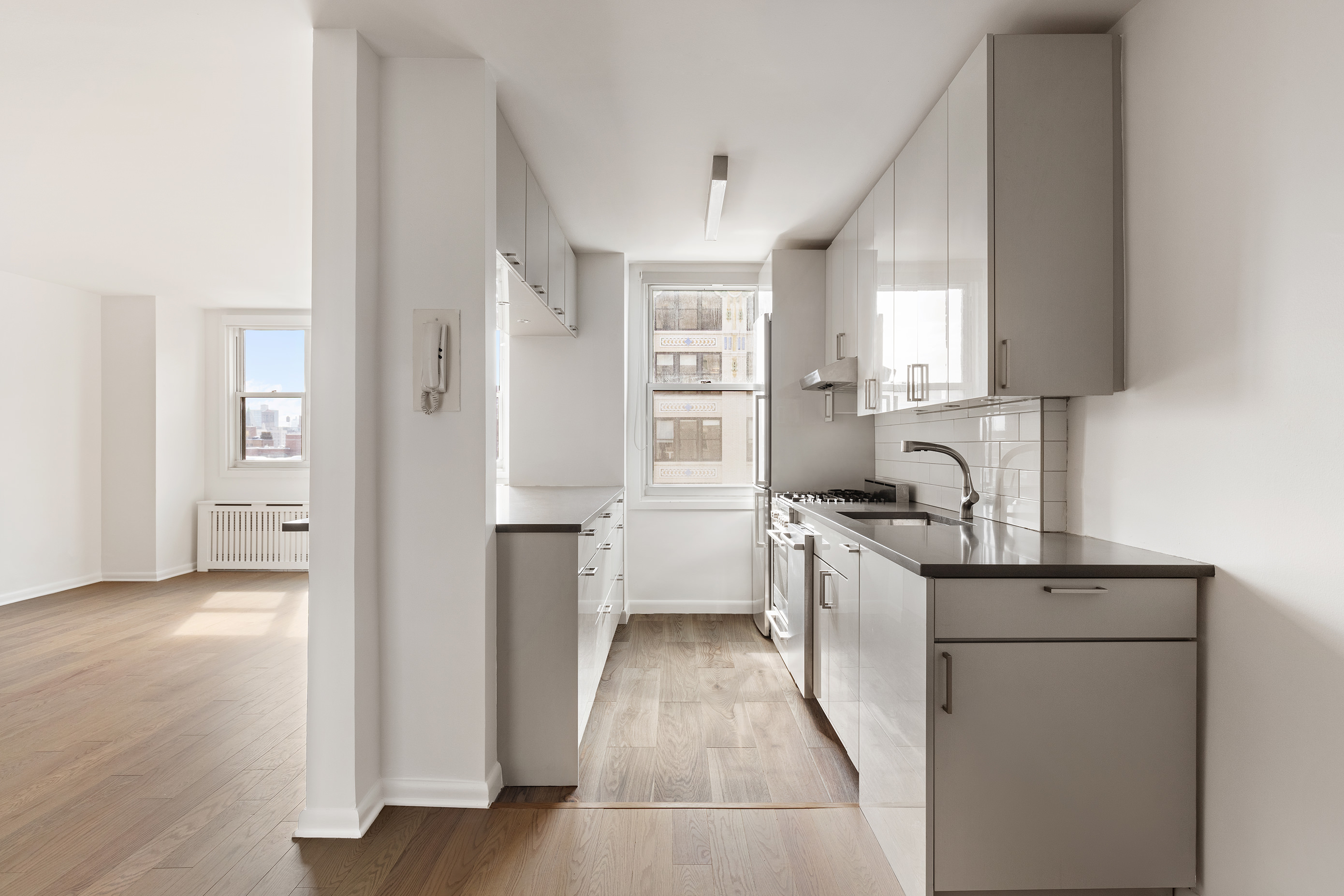 77 7th Avenue, Unit 12P Manhattan, NY 10011 - Photo 9 of 15 a kitchen with white cabinets and sink