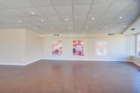 an empty room with wooden floor and natural light