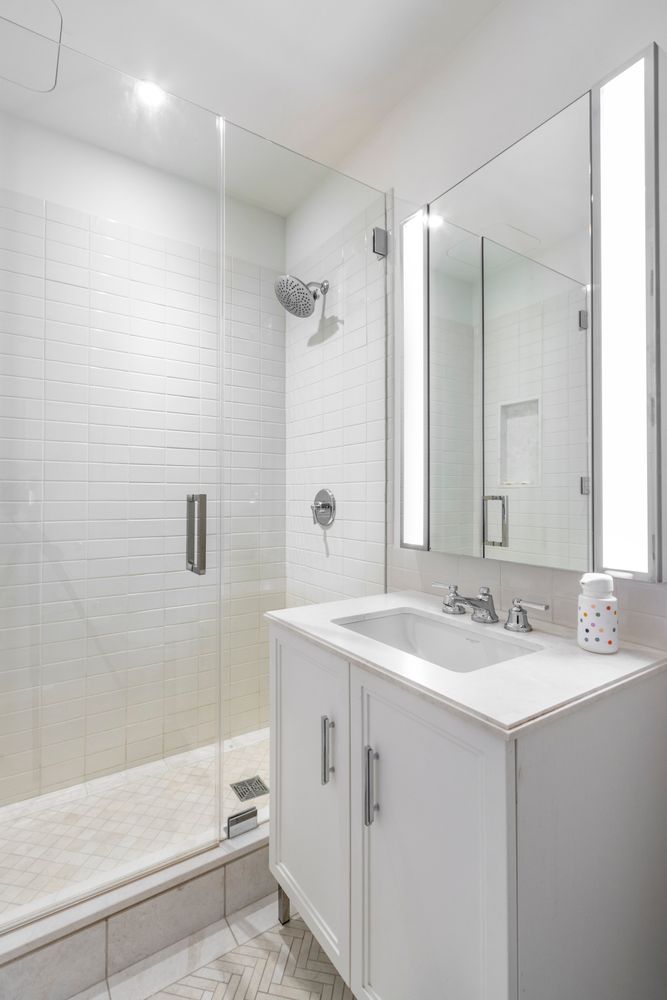 100 Barclay Street, Unit 17J Manhattan, NY 10007 - Photo 8 of 18 a bathroom with a sink double vanity mirror and a shower