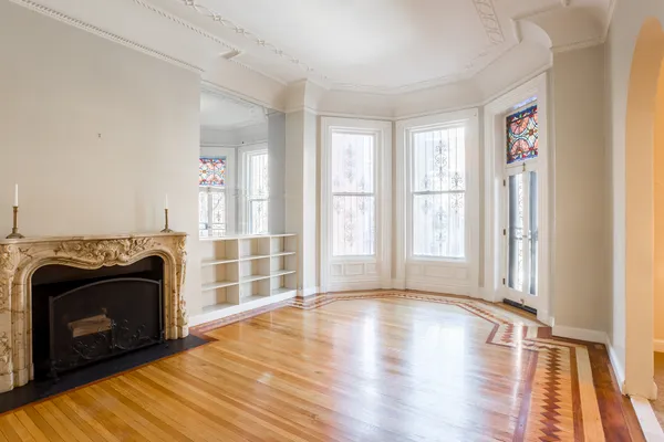 a view of an empty room with glass door and wooden floor