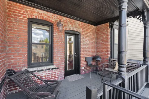 a view of a balcony with chairs and wooden floor
