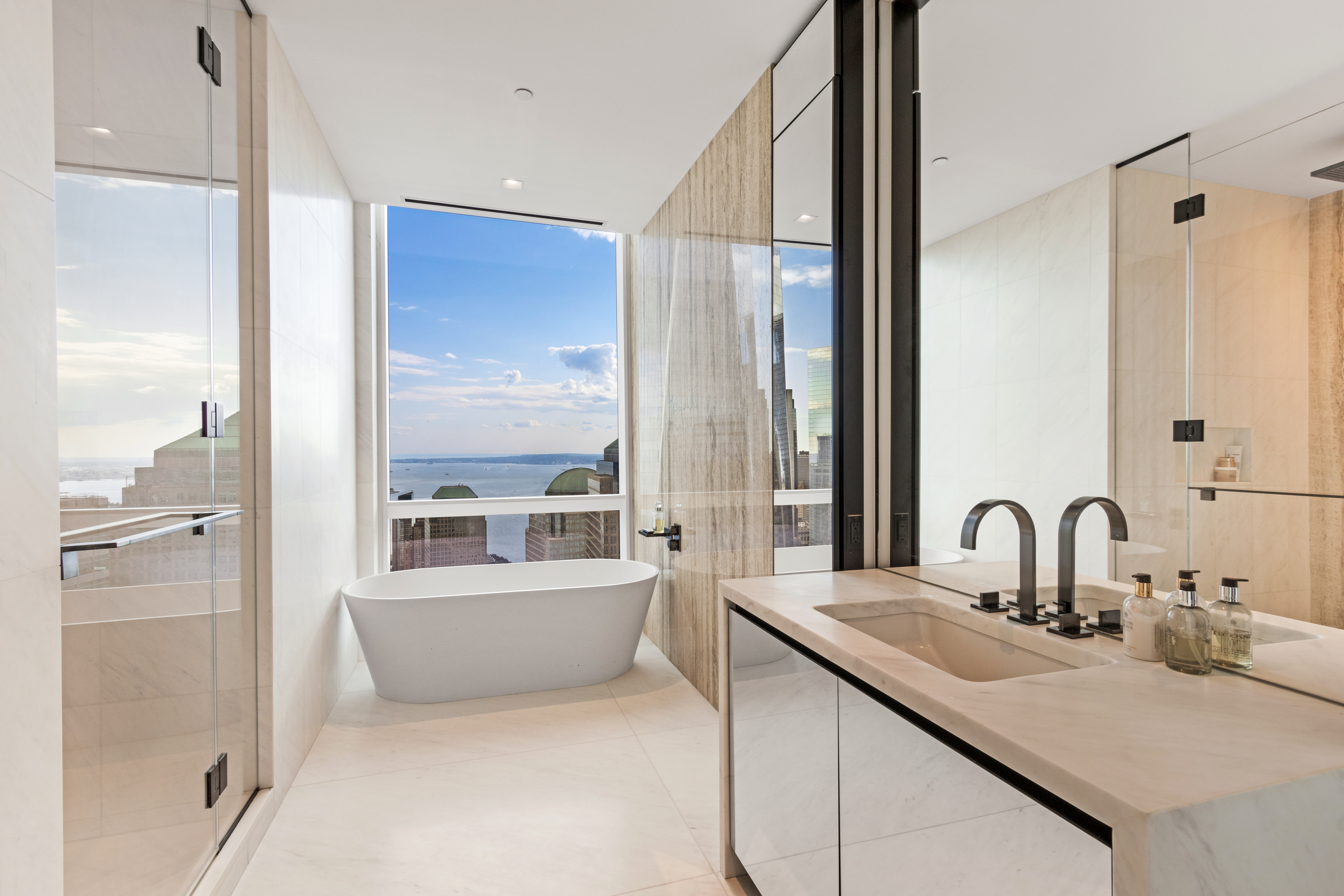 111 Murray Street, Unit 61W Manhattan, NY 10007 - Photo 20 of 35 a bathroom with a tub sink and mirror