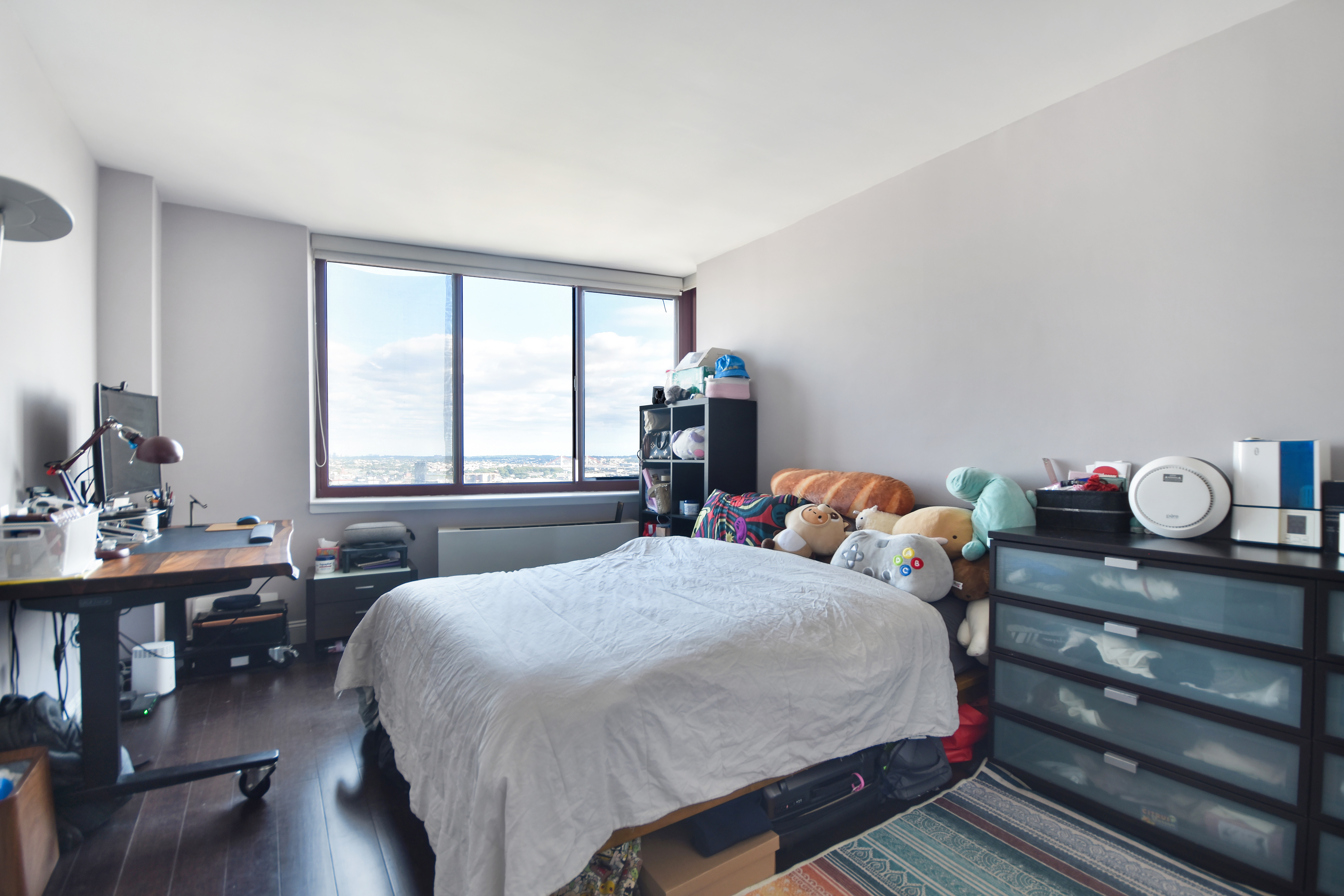 4-74 48th Avenue, Unit 34G Queens, NY 11109 - Photo 1 of 9 a bedroom with a bed and a table