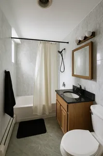 a bathroom with a granite countertop sink toilet a mirror and shower
