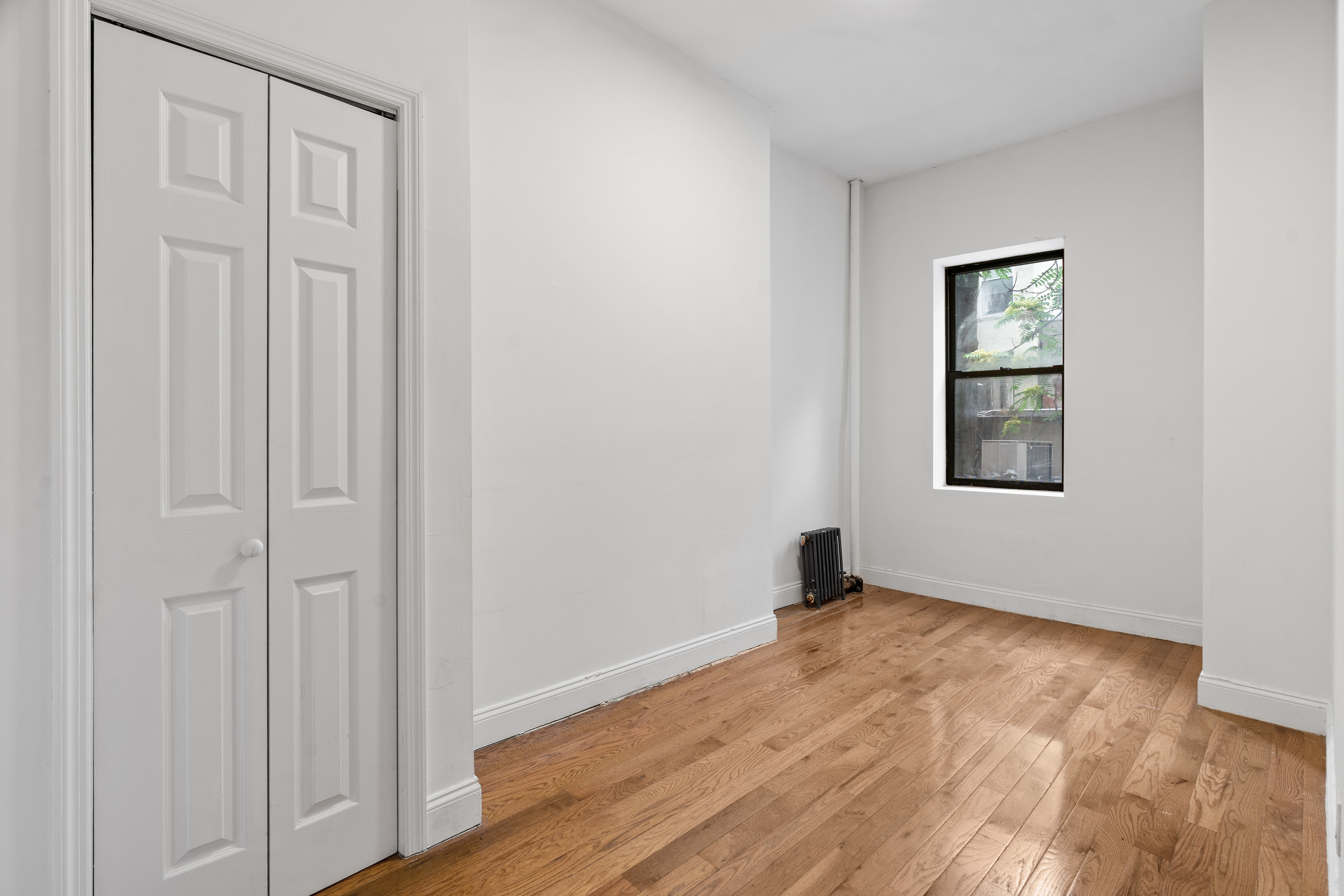 31 St Marks Place, Unit 1 Manhattan, NY 10003 - Photo 4 of 11 an empty room with wooden floor closet and windows