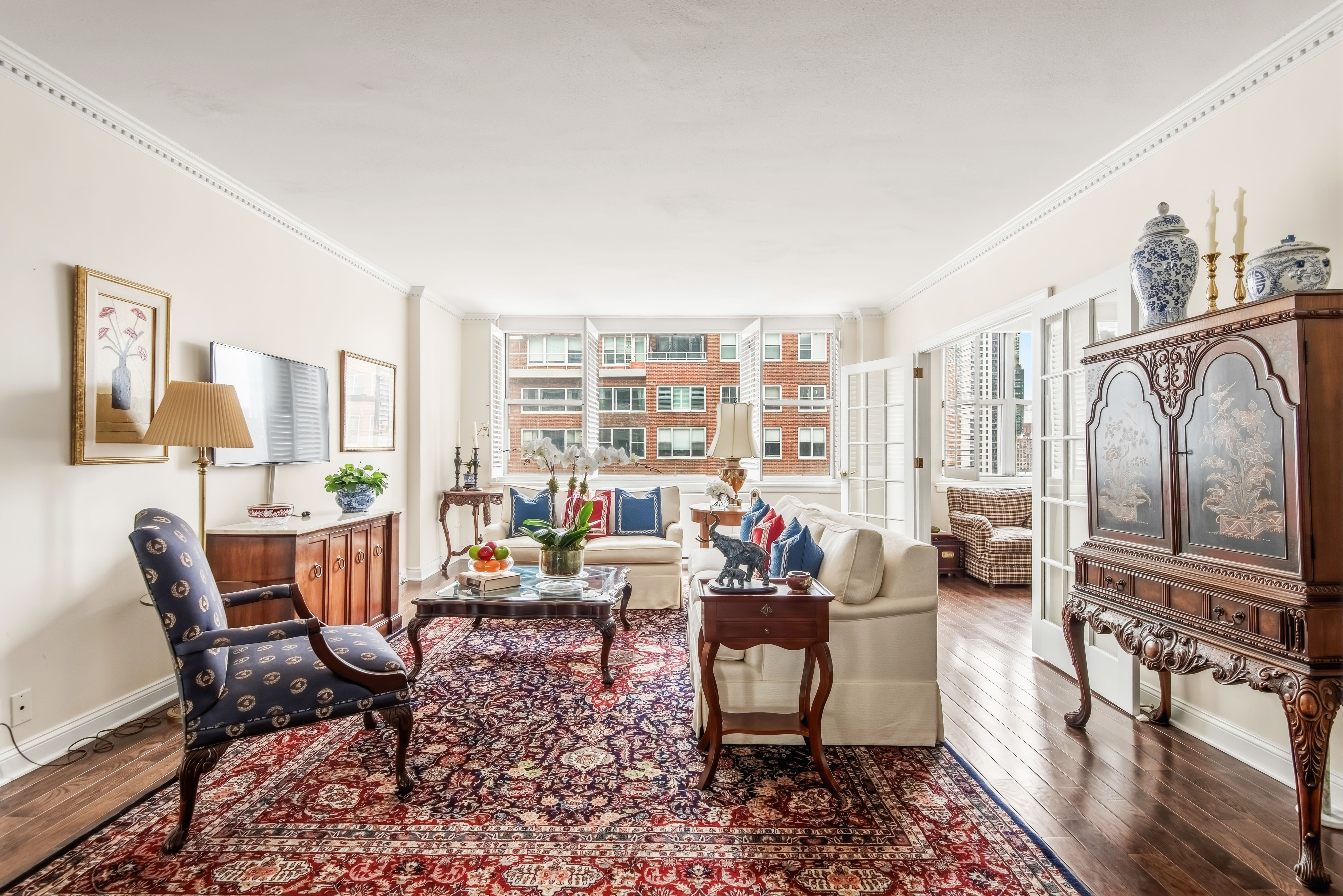 175 East 62nd Street, Unit 14B Manhattan, NY 10065 - Photo 4 of 12 a living room with furniture and a floor to ceiling window
