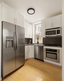 a kitchen with a refrigerator sink and cabinets
