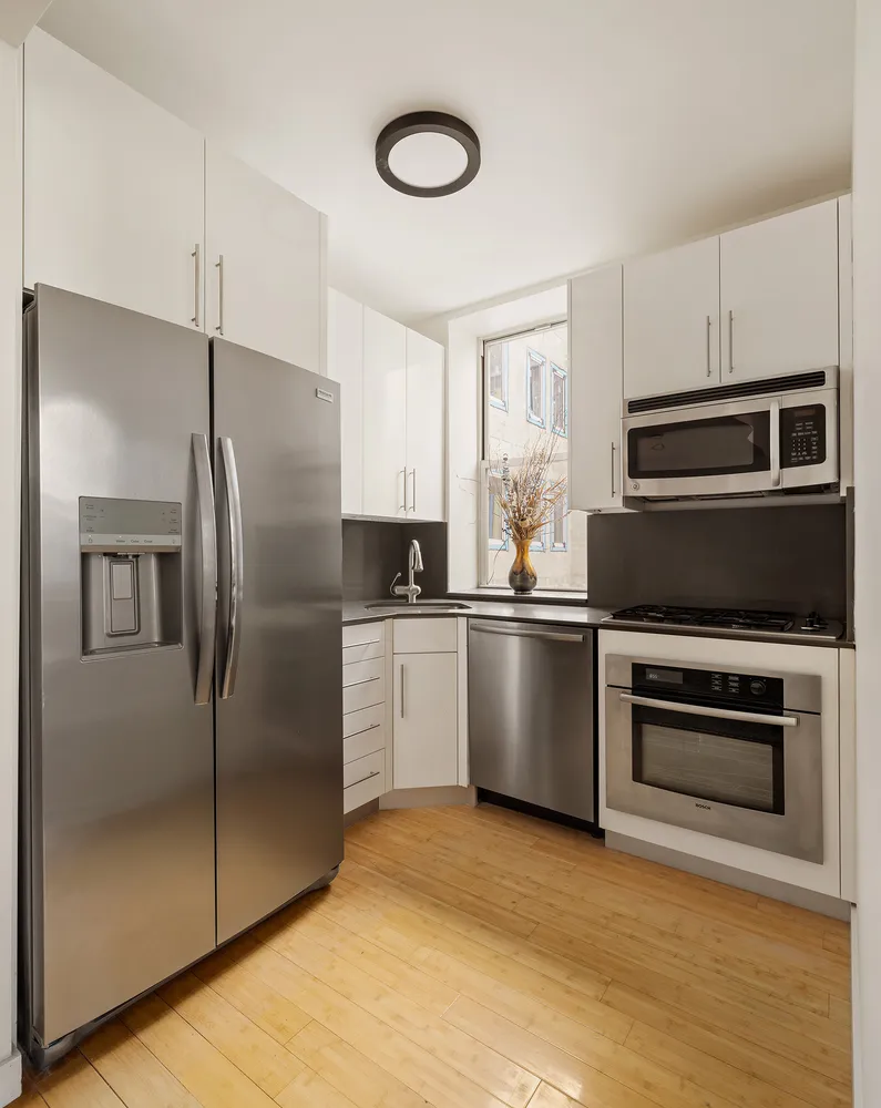 a kitchen with a refrigerator sink and cabinets