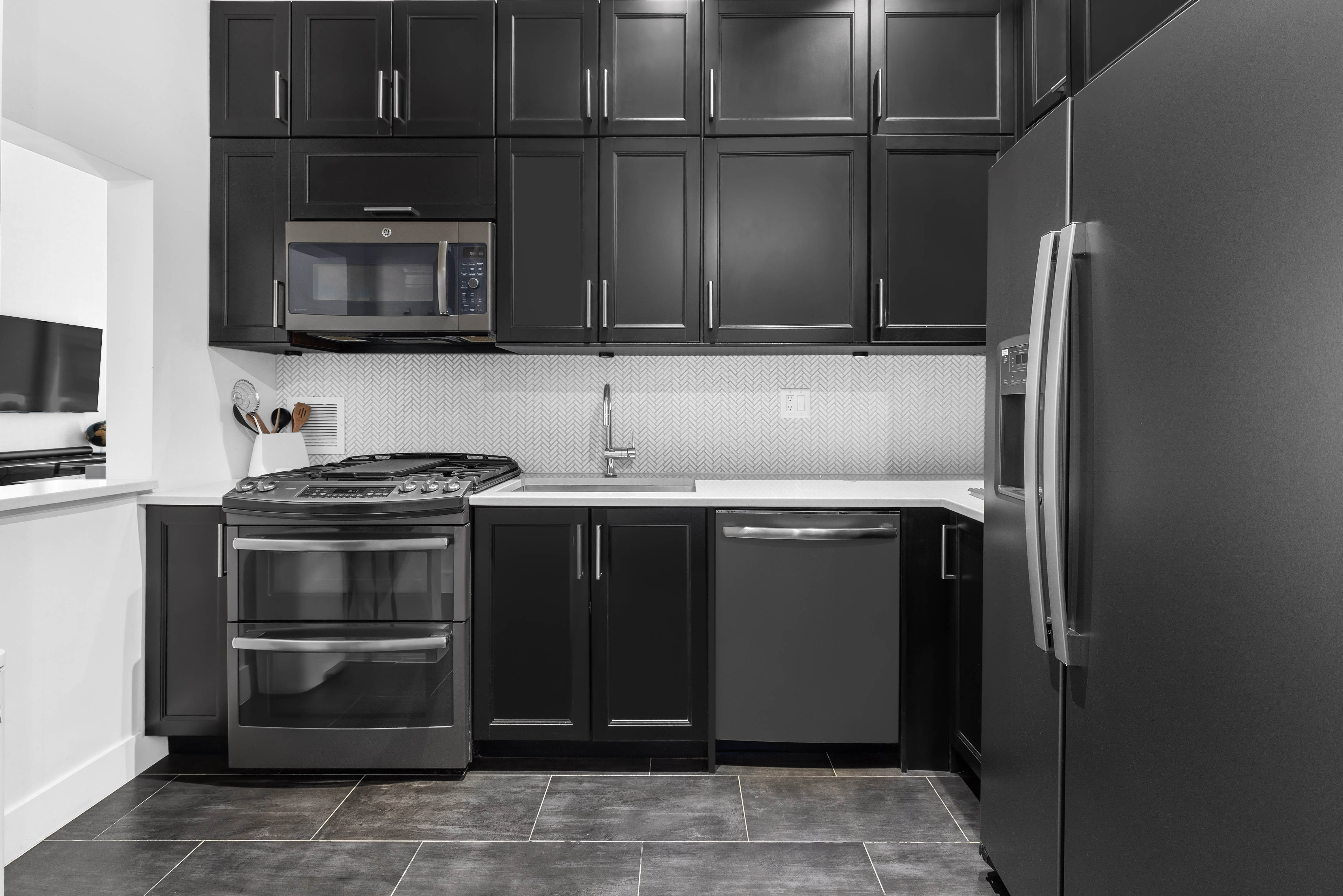 372 5th Avenue, Unit 5F Manhattan, NY 10018 - Photo 2 of 9 a kitchen with granite countertop a refrigerator and a stove top oven