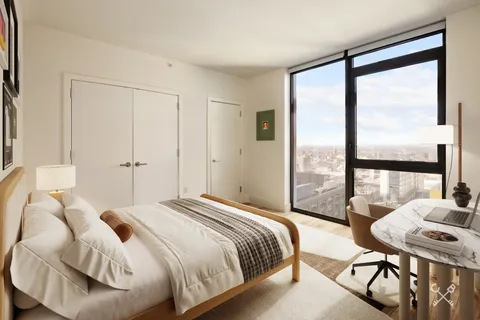 a bedroom with a bed and a table next to a window