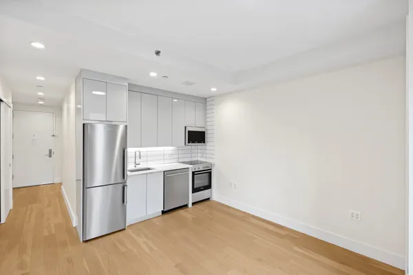 a kitchen with stainless steel appliances granite countertop a refrigerator and a stove top oven