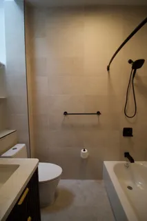 a bathroom with a sink a toilet and shower